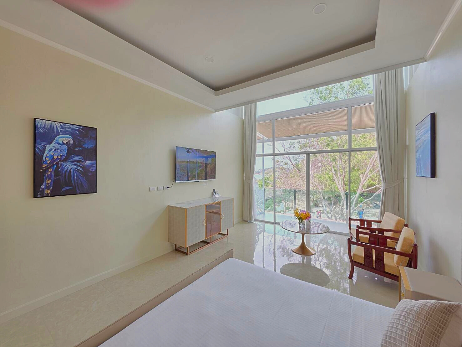 Spacious guest room with TV and tropical garden view at Ta Yai Beach Resort, Koh Larn